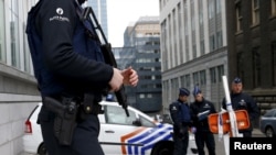 FILE - Belgian police officers secure an access to the federal police headquarters in Brussels, March 19, 2016, after Salah Abdeslam, the most-wanted fugitive from November's Paris attacks, was arrested after a shootout with police in Brussels on Friday.