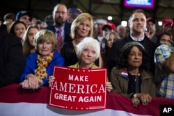 FILE - Supporters of Republican presidential candidate Donald Trump watch him speak during a campaign rally in Grand Rapids, Michigan, Oct. 31, 2016.