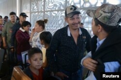 Central American migrants line up to enter the U.S., asking for refuge and to be reunited with the children they were separated from by immigration authorities when they crossed into the United States illegally last year, at the border crossing in Mexicali/Tijuana, Mexico.