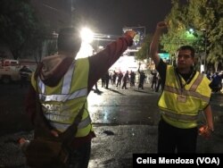 Volunteers working with the rescue teams in Mexico City signal to keep silent. The close fist is a sign to be quiet in order for the rescuers to listen and identify the location of survivors.