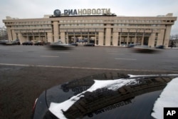 FILE - Cars pass by the former Russian RIA Novosti information agency headquarters in Moscow, Dec. 9, 2013. Major brands in the export division of Russian media include RT, the RIA Novosti news agency, Sputnik and the Voice of Russia radio station.