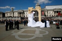 London Mayor Boris Johnson (center L) watches as a 5.5-meter (20ft) recreation of the 1,800-year-old Arch of Triumph in Palmyra, Syria, is unveiled at Trafalgar Square in London, Britain, April 19, 2016.