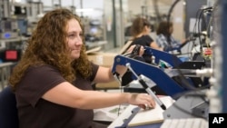 FILE - Sennheiser employee Antoinette Lucero inspects circuit boards at her work station at their plant in Albuquerque, N.M. She learned about a free program by Manpower Inc. to earn certification in electronics assembly.