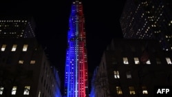 FILE - Rockefeller Center and Rockefeller Plaza is lit up in red and blue to mark the electoral progress of Hillary Clinton and Donald Trump and a map of the United States was superimposed on the skating rink, Nov. 7, 2016.