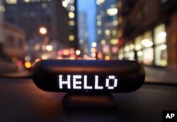 In this image distributed on Thursday, Feb. 9, 2017, Lyft’s new Amp glows on the dashboard of a car in San Francisco.