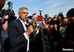 Britain's newly elected mayor Sadiq Khan speaks to supporters as he arrives for his first day at work at City Hall in London, May 9, 2016.