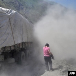 美国之音记者何宗安被汽车卷起的漫天尘土包围