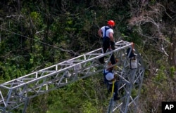 FILE - Whitefish Energy Holdings workers restore power lines damaged by Hurricane Maria in Barceloneta, Puerto Rico, Oct. 15, 2017.