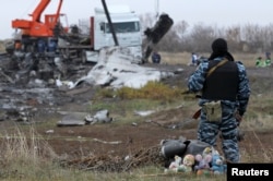 A pro-Russian armed man secures crash site wreckage of the Malaysia Airlines Flight MH17 at the site of the plane crash near the settlement of Grabovo in the Donetsk region, Nov. 16, 2014.