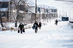 People whose homes didn’t burn in a wildfire evacuate their belongings, Jan. 1, 2022, in Superior, Colorado