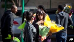 Granddaughter Ndileka Mandela, center, gestures as she and other family relatives carry bunches of flowers that were left by wellwishers into the Mediclinic Heart Hospital, June 27, 2013.