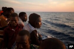 Sub-Saharan migrants stand on the deck of the Golfo Azzurro rescue vessel as they arrive at the port of Pozzallo, Italy, June 17, 2017.