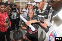 អ្នកស្រី​ង៉ែត ឃុន សកម្មជនសហគមន៍​បឹងកក់ ត្រូវ​ក្រុមសមត្ថកិច្ច​ចាប់​ឲ្យ​នៅ​មួយកន្លែង​ខណៈពេល​ដែល​តវ៉ាទាមទារ​ឲ្យដោះលែង​អ្នកស្រី​បូវ​ សោភា​ ​នៅ​មុខ​សាលាតំបូង​រាជធានី​ភ្នំពេញ កាលពីថ្ងៃទី១៧ ខែសីហា ឆ្នាំ២០១៦។ (ឡេង ឡែន/VOA)