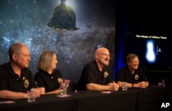 A new image of Ultima Thule, right, is displayed during a press conference featuring, from left, principal investigator Alan Stern, operations manager Alice Bowman, systems engineer Chris Hersman, and project scientist Hal Weaver.