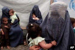 FILE - Returning Afghan refugees, who have recently arrived from Pakistan, wait during the registration process at a United Nations High Commissioner for Refugees (UNHCR) center on the outskirts of Kabul, Afghanistan, June 20, 2013.