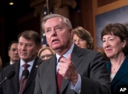 FILE - Sen. Lindsey Graham, R-S.C., flanked by Sen. Mike Rounds, R-S.D., left, and Sen. Susan Collins, R-Maine, discusses efforts to reach agreement on immigration reform, during a news conference at the Capitol in Washington, Feb. 15, 2018.
