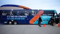Patients wait to enter a mobile vaccination unit parked outside Ball Arena before the start of an NBA basketball game as the Denver Nuggets host the Charlotte Hornets, Dec. 23, 2021, in Denver. The state of Colorado has several mobile units traveling around the state to bring vaccinations to places where people gather such as arenas.