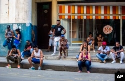 In this Jan. 6, 2017 photo, people use a public wifi hotspot in Havana, Cuba. Home internet came to Cuba in December 2016, in a limited pilot program