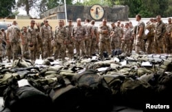 German Bundeswehr army soldiers of the ISAF, who have completed the term of their deployment in Afghanistan, wait for their luggage to go through a security check before their flight back to Germany at an army airbase in Termez, Uzbekistan