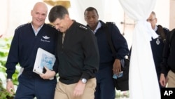 FILE - Air Force Gen. Carlton D. Everhart, the Commander of Air Mobility Command, left, holds a binder with a photograph of Air Force One on the cover as he speaks to Navy Adm. Bill Moran, Vice Chief of Naval Operations, second from left, while arriving with other generals and admirals for a meeting with President-elect Donald Trump at Mar-a-Lago, in Palm Beach, Fla., Dec. 21, 2016.