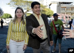 Presidential candidate Carlos Alvarado, right, with the Citizen Action party, greats a supporter as he arrives to a Mass at La Soledad church before casting his ballot during general elections in San Jose, Costa Rica, Feb. 4, 2018.
