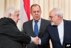 Russian Foreign Minister Sergei Lavrov, center, stands in the middle as Syrian Foreign Minister Walid Muallem, left, and Iranian Foreign Minister Mohammad Javad Zarif shake hands after a shared press conference following their talks focused on Syria in Moscow, Russia, April 14, 2017.