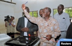 Tanzanian presidential candidate of the ruling CCM party, John Magufuli, displays his ballot paper before casting his vote in the presidential and parliamentary election at his hometown Chato district, in Geita region, Tanzania, Oct. 25, 2015.