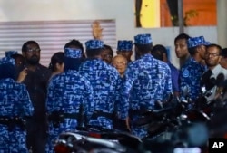 Police arrest Maumoon Abdul Gayoom, center, a former Maldives president and opposition leader, after the government declared a 15-day state of emergency in Male, Maldives, Feb. 6, 2018.