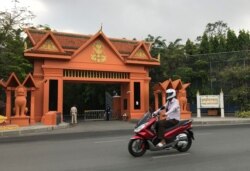 បុរសម្នាក់កំពុងជិះម៉ូតូកាត់​អគារ​ក្រុមប្រឹក្សា​រដ្ឋធម្មនុញ្ញ លើមហាវិថីព្រះមុនីវង្ស រាជធានីភ្នំពេញ ថ្ងៃទី២៨ ខែមេសា ឆ្នាំ២០២០។ (កាន់ វិច្ឆិកា/VOA)