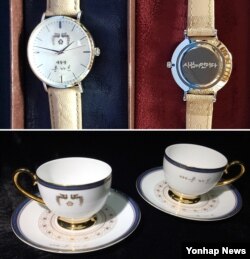 문재인 대통령의 친필 사인이 새겨진 손목 시계(사진 위)와 찻잔 세트.