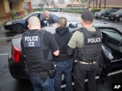 FILE - A photo released by U.S. Immigration and Customs Enforcement shows foreign nationals being arrested during a targeted enforcement operation in Los Angeles, Feb. 7, 2017.