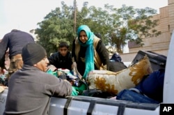 Iraqi security forces and allied Sunni tribal fighters help trapped civilians get to safer areas in Ramadi, 70 miles (115 kilometers) west of Baghdad, Iraq, on Jan. 2, 2016, after multiple IS suicide bombings.