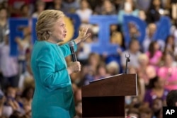 Members of the audience hold signs that spell out "Florida" as Democratic presidential candidate Hillary Clinton speaks at a rally at Palm Beach State College in Lake Worth, Florida, Oct. 26, 2016.
