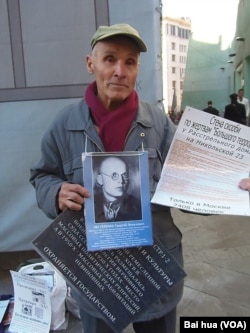 涅斯杰连科手持被处决的父亲照片，以及介绍当年最高军事法庭的资料，他呼吁把最高军事法庭遗址改建成红色恐怖博物馆 (美国之音白桦拍摄)