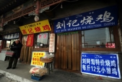 资料照：河北沧州一名回族男子走过有着汉字和伊斯兰字样招牌的清真餐馆。（2009年2月26日）