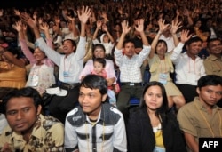 FILE - Indonesian couples gesture as they attend a mass interfaith wedding ceremony sponsored by an organizer and the Jakarta government in Jakarta on July 19, 2011.