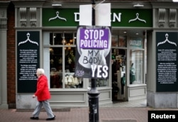 A woman walks past a pro-choice poster in the city centre of Dublin, Ireland, May 22, 2018.