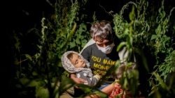 در این عکس که به تاریخ ۱۸ آگست ۲۰۲۱ گرفته شده است، یک مهاجر از افغانستان همراه با کودک اش در نزدیکی شهر تتوان واقع در ولایت شرقی بیتلیس به سر می برد