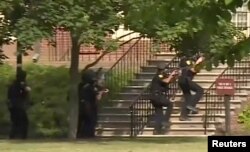 Police enter a building following a shooting at the municipal center in Virginia Beach, Va., May 31, 2019, in this still image taken from video.