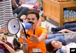 Marjorie Stoneman Douglas High School student David Hogg speaks as demonstrators lie on the floor at a Publix Supermarket in Coral Springs, Fla., May 25, 2018.