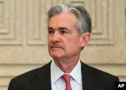 FILE - Federal Reserve Gov. Jerome Powell talks with others before a Board of Governors meeting in Washington, Nov. 30, 2015.