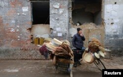 지난 2013년 2월 재개발을 위한 철거 작업이 진행 중인 노후 주택가에서 노점상이 손님을 기다리고 있다.