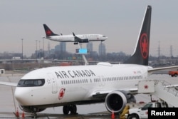 An Air Canada Boeing 737 MAX 8 from San Francisco approaches for landing at Toronto Pearson International Airport over a parked Air Canada Boeing 737 MAX 8 aircraft in Toronto, Ontario, Canada, March 13, 2019.