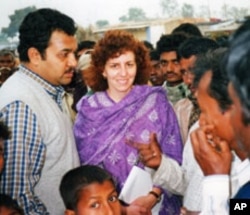 Ellyn Ogden and Dr. Saurabh Sharma, WHO Surveillance Focal Point/Bihar, check the fingers of every child in the market for ink-marks - a sign that the child was immunized during the round.