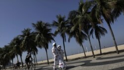 Tercio Galdino, 66, and his wife Aliceia, 65, wear their protective 'space suits' as they walk on the sidewalk of Copacabana Beach amid the outbreak of the coronavirus disease (COVID-19) in Rio de Janeiro, Brazil, July 11, 2020.