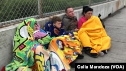 Migrants from Venezuela, Cuba and Guatemala wait at bridge between Matamoros, Mexico and Brownsville, Texas for immigration officials to allow them to turn themselves in and ask for asylum in U.S., Nov. 12, 2018.