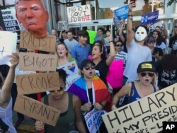 Protesters hold banners during a rally outside the CNN studio in opposition to President-elect Donald Trump, in the Hollywood section of Los Angeles, Nov. 13, 2016.