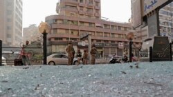 Tentara Lebanon berdiri di dekat jalanan yang dipenuhi pecahan kaca di kota Beirut. Bentrokan yang terjadi di kota itu pada 14 Oktober 2021 menewaskan tujuh orang. (Foto: AFP)