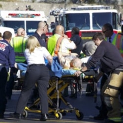 Emergency workers treat a victim of the shooting at a Tucson shopping center