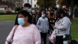 People wait in line for a COVID-19 test at a mobile testing site in Paramount, California, Jan. 12, 2022.
